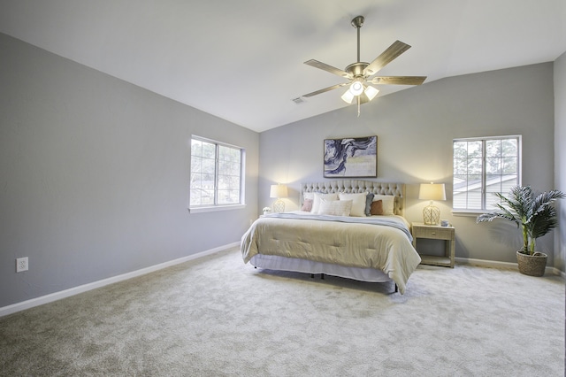 carpeted bedroom with vaulted ceiling, ceiling fan, and multiple windows