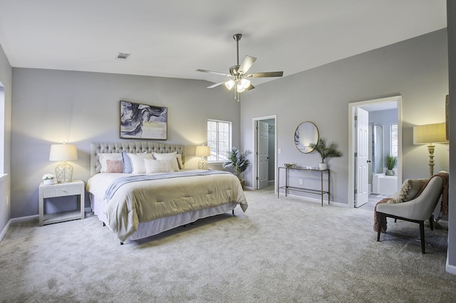 bedroom with lofted ceiling, ensuite bath, ceiling fan, and carpet flooring