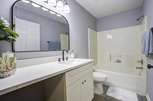 full bathroom featuring toilet, wood-type flooring, vanity, and bathing tub / shower combination