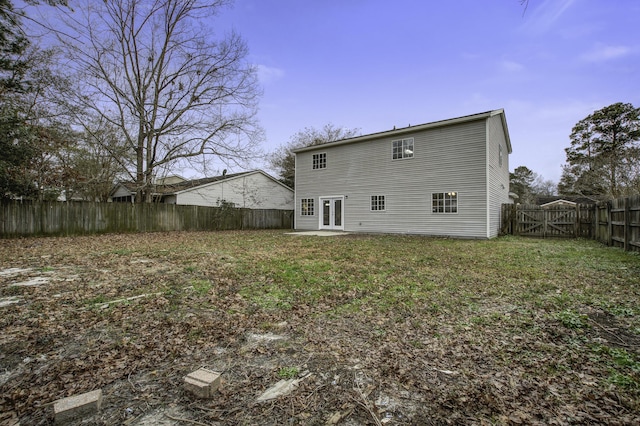 rear view of property with french doors and a yard