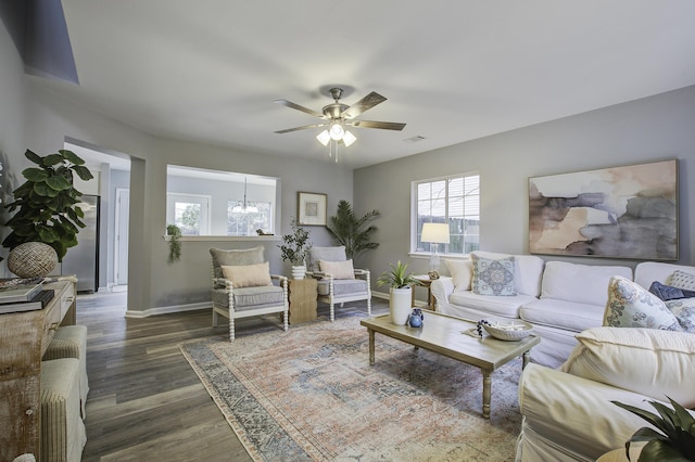 living room with ceiling fan with notable chandelier, dark hardwood / wood-style floors, and plenty of natural light