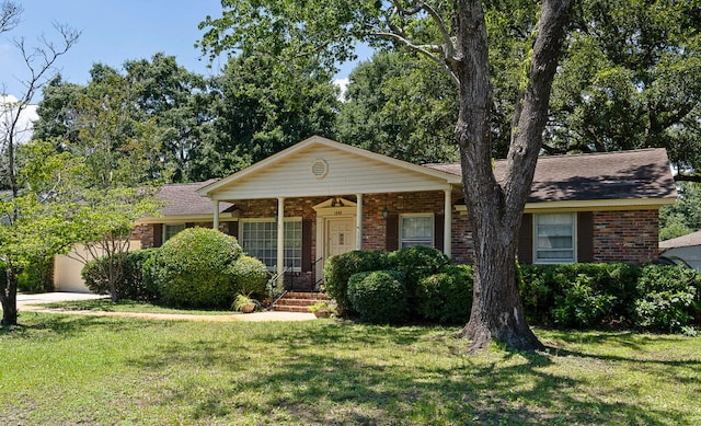 view of front facade with brick siding, a shingled roof, a porch, a front yard, and a garage