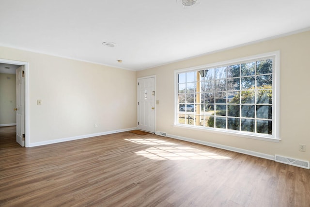 interior space with wood finished floors, visible vents, and baseboards