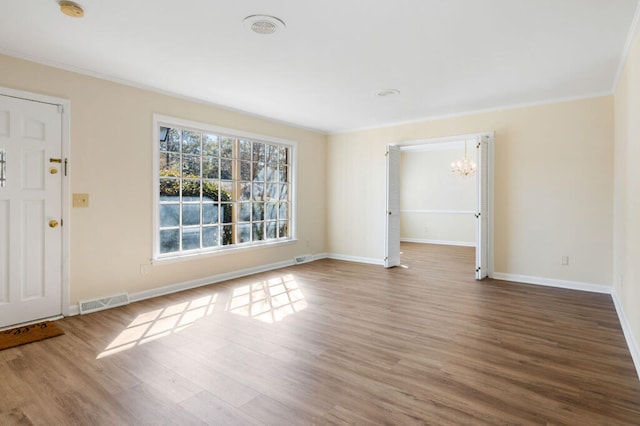 interior space featuring visible vents, wood finished floors, baseboards, and a chandelier