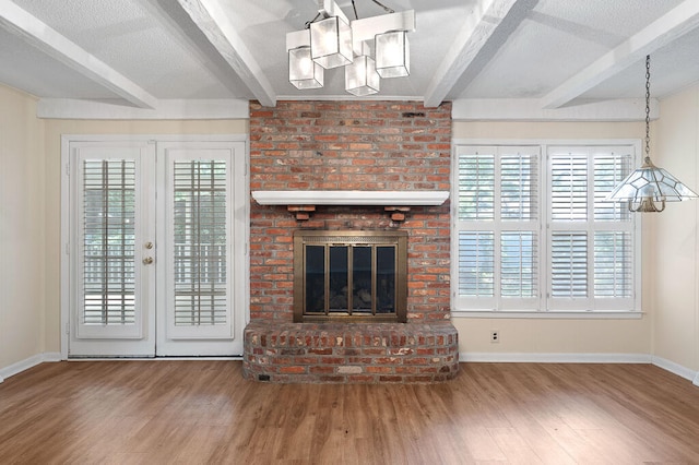 unfurnished living room featuring beam ceiling, a textured ceiling, and wood finished floors