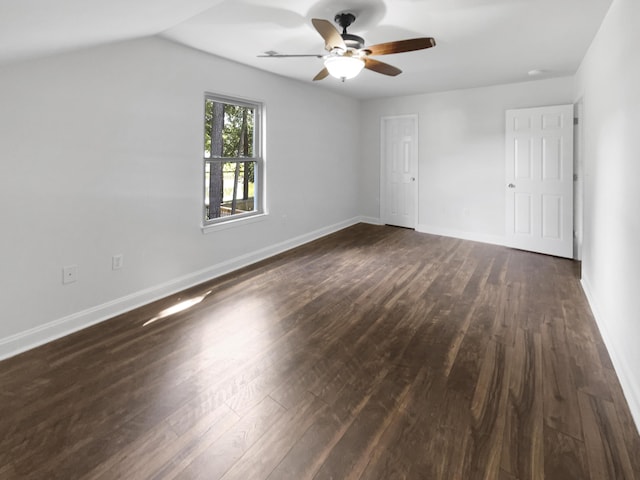 unfurnished bedroom featuring dark wood-style flooring, baseboards, a ceiling fan, and lofted ceiling
