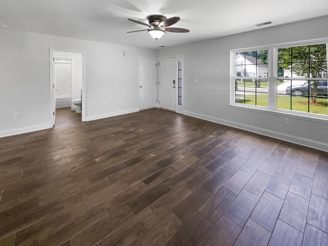 unfurnished living room featuring ceiling fan, dark wood finished floors, and baseboards