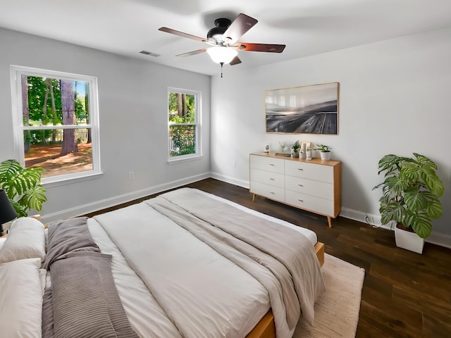 bedroom with baseboards, dark wood-style floors, and a ceiling fan