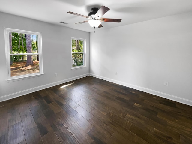 spare room featuring ceiling fan, baseboards, and dark wood-style floors