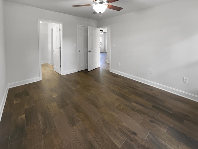 spare room with ceiling fan, dark wood finished floors, and baseboards