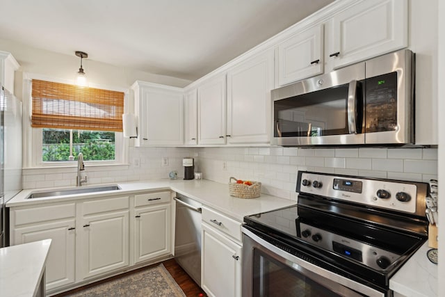 1107 S Shadow Dr, Mount Pleasant, SC 29464 - kitchen featuring stainless steel appliances, a sink, white cabinets, decorative backsplash, and light countertops