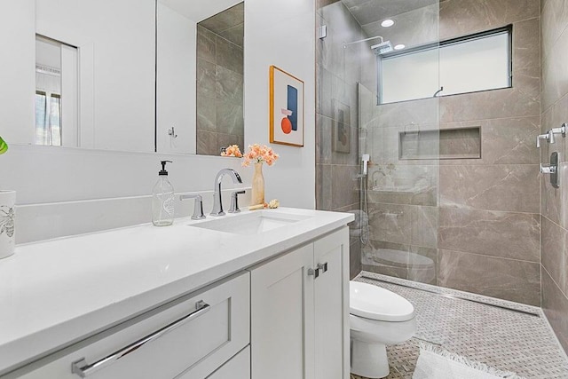 bathroom with vanity, plenty of natural light, a shower with shower door, and toilet