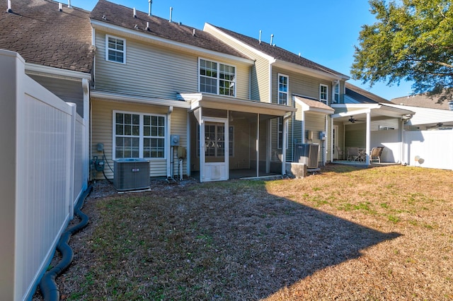 rear view of house featuring cooling unit and a yard