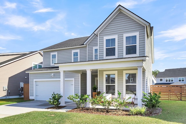 view of front of house with covered porch, a front yard, and a garage