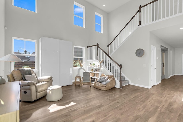 living room featuring a towering ceiling and wood-type flooring