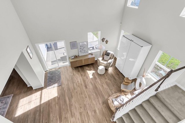 living room with a towering ceiling and wood-type flooring