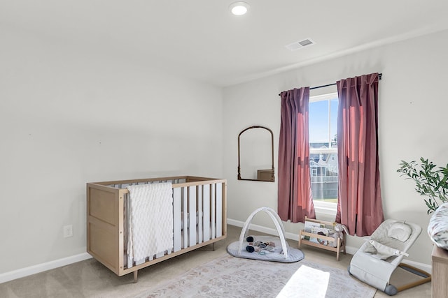 carpeted bedroom featuring a crib