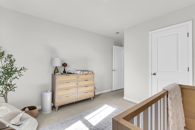 carpeted bedroom featuring a nursery area