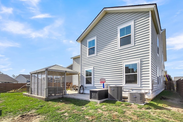 back of house featuring central AC, a yard, and a patio