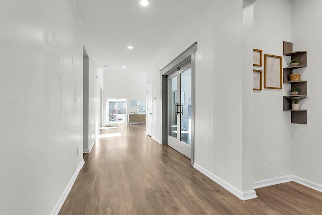 hall with hardwood / wood-style flooring and french doors