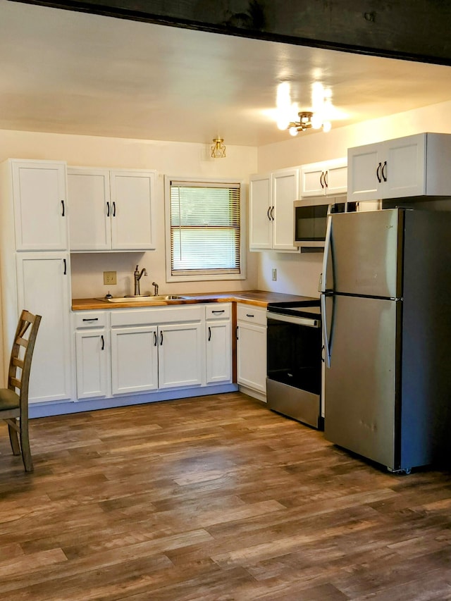 kitchen with appliances with stainless steel finishes, light hardwood / wood-style flooring, and white cabinetry