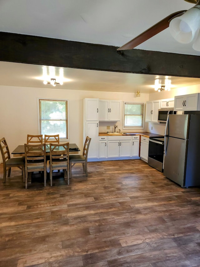 kitchen featuring white cabinets, dark hardwood / wood-style floors, beamed ceiling, and appliances with stainless steel finishes