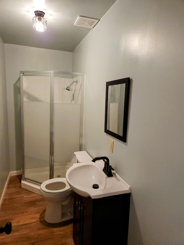 bathroom with walk in shower, toilet, vanity, and hardwood / wood-style flooring