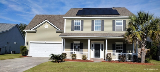 view of front of property with a front lawn, covered porch, a garage, and solar panels