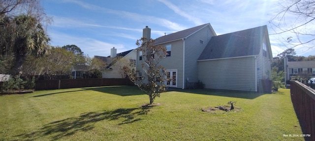 view of side of property featuring a yard and french doors