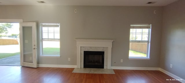 unfurnished living room featuring a high end fireplace and hardwood / wood-style floors