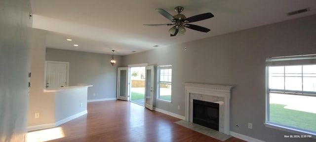 unfurnished living room featuring a fireplace, plenty of natural light, and wood-type flooring