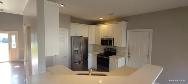 kitchen featuring white cabinets, sink, kitchen peninsula, and stainless steel appliances