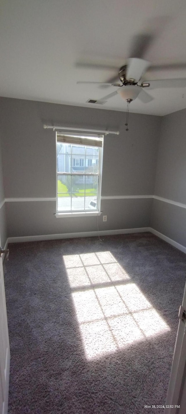 carpeted spare room with ceiling fan