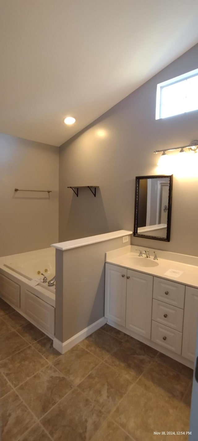 bathroom featuring tile patterned floors, vanity, and vaulted ceiling