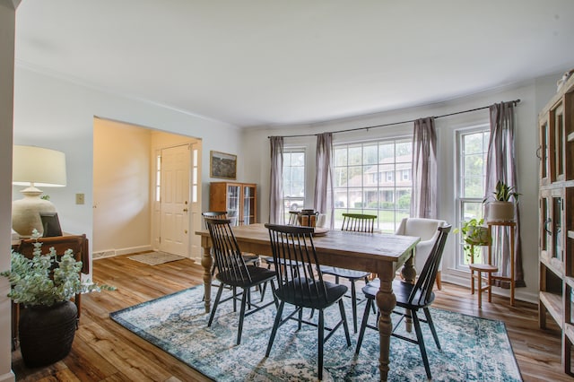 dining space featuring ornamental molding and hardwood / wood-style flooring