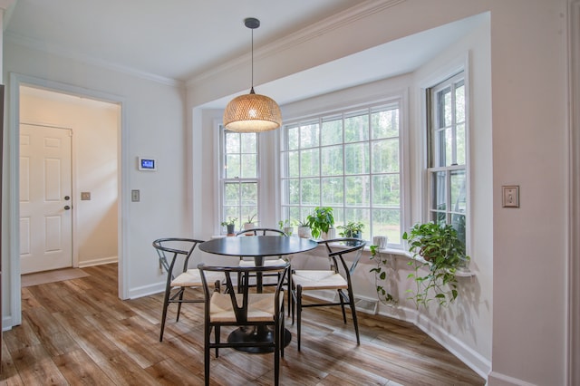 dining space with ornamental molding, hardwood / wood-style flooring, and a wealth of natural light