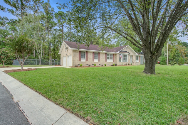 ranch-style house featuring a front yard and a garage