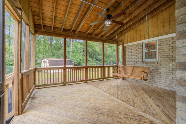 unfurnished sunroom featuring lofted ceiling, ceiling fan, a wealth of natural light, and wood ceiling