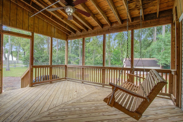 unfurnished sunroom featuring lofted ceiling, ceiling fan, wooden ceiling, and a healthy amount of sunlight