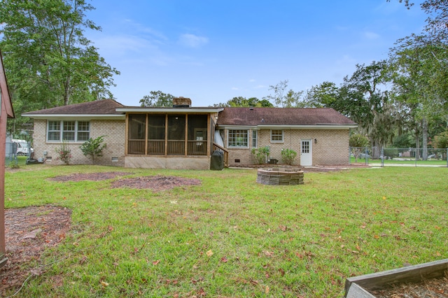 view of front of home with an outdoor fire pit, a front yard, and a sunroom