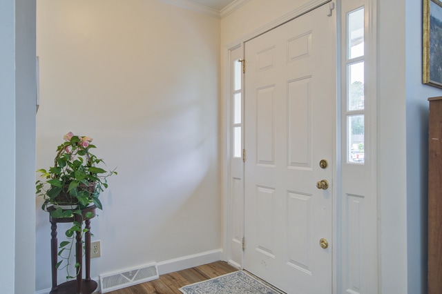 foyer entrance featuring hardwood / wood-style floors and crown molding