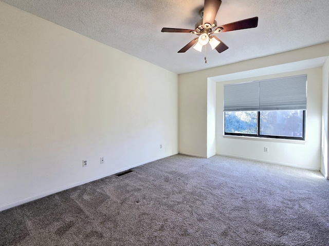 carpeted spare room with ceiling fan and a textured ceiling