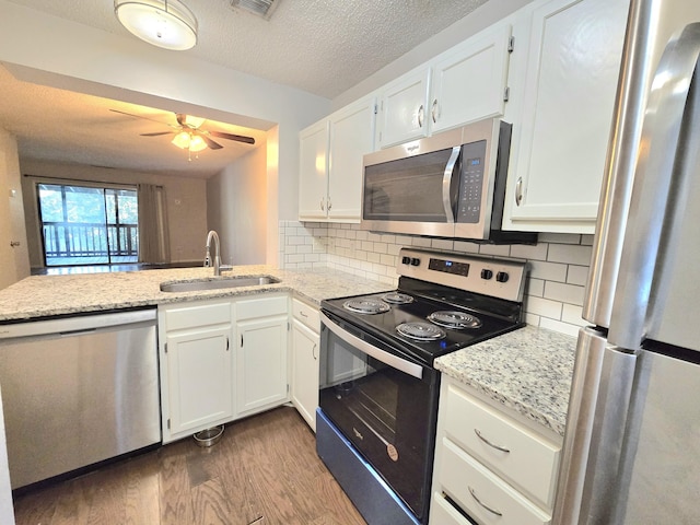 kitchen featuring decorative backsplash, sink, white cabinetry, and appliances with stainless steel finishes