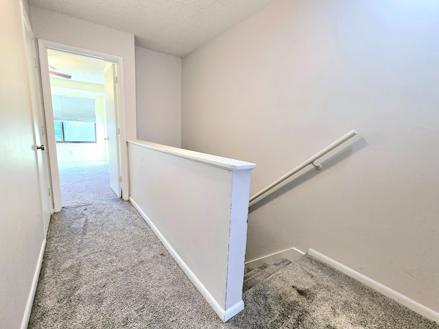 corridor featuring carpet floors and a textured ceiling