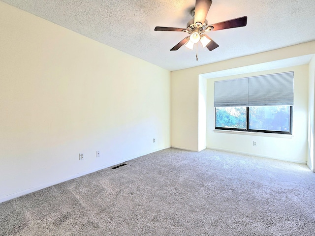 carpeted spare room with a textured ceiling and ceiling fan