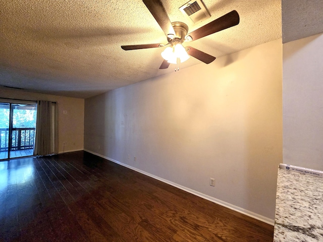 spare room with a textured ceiling, dark hardwood / wood-style floors, and ceiling fan