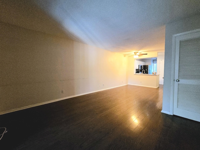 spare room with ceiling fan, a textured ceiling, and dark hardwood / wood-style flooring