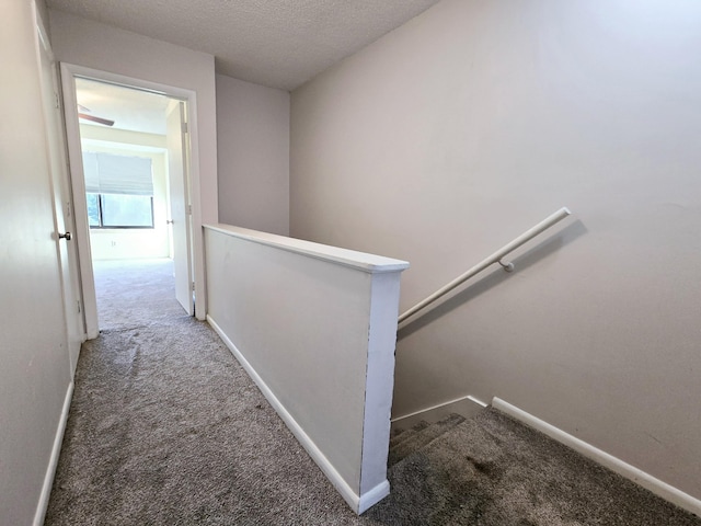 hallway featuring a textured ceiling and carpet floors