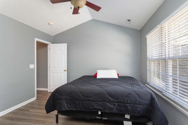 bedroom with dark hardwood / wood-style flooring, vaulted ceiling, and ceiling fan