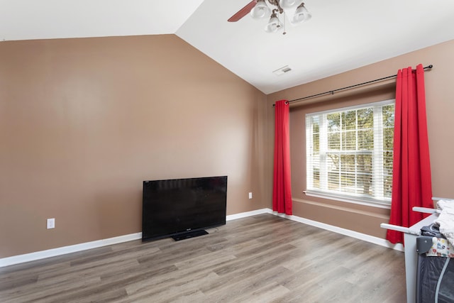 spare room featuring ceiling fan, wood-type flooring, and vaulted ceiling